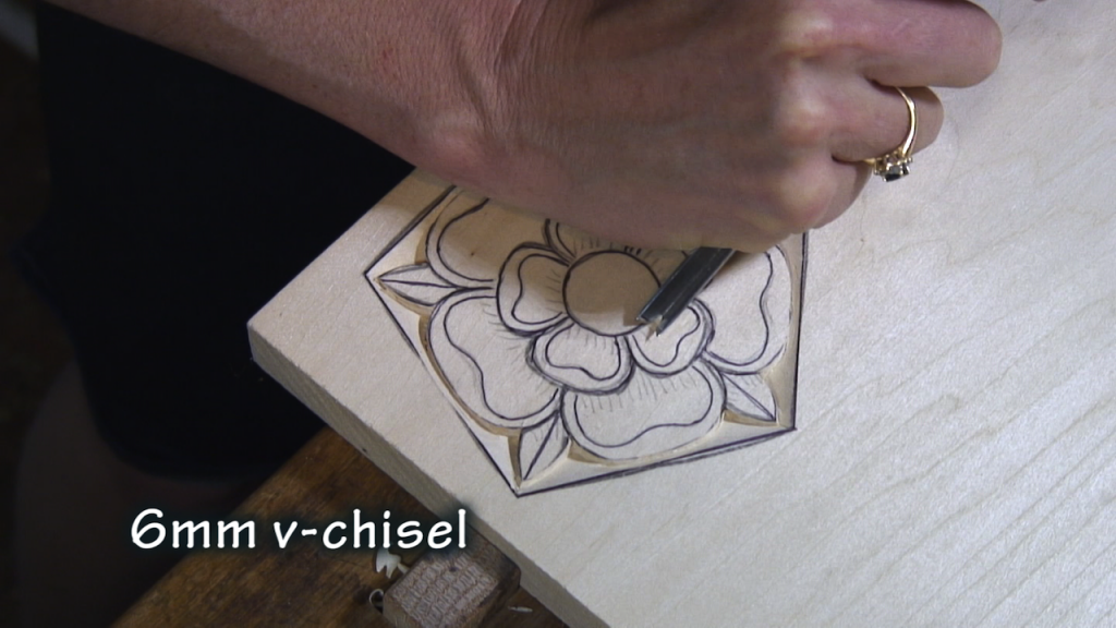 With a v-chisel, carve around the center of the rose.