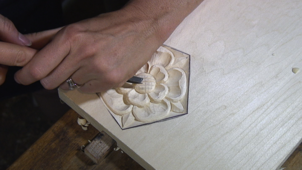With a v-chisel, make v-cuts in a cross-hatch pattern in the center of the rose.