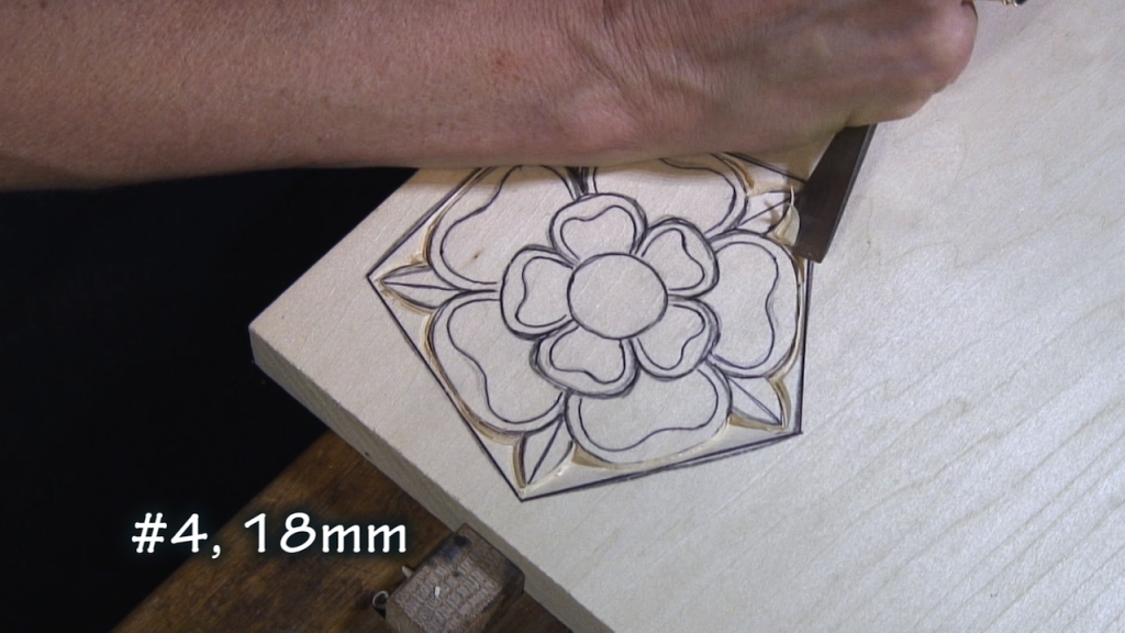 With a #4, 18mm, make an angle cut from the straight outside frame edge to the edge of the rose.
