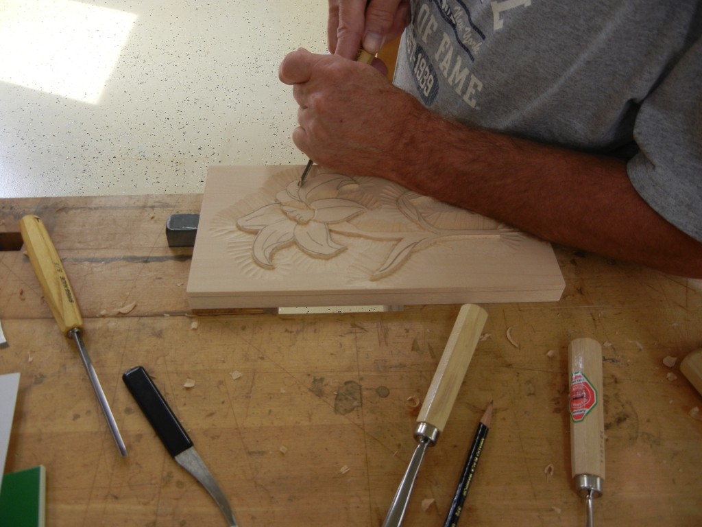 Student carving a lilly in relief.