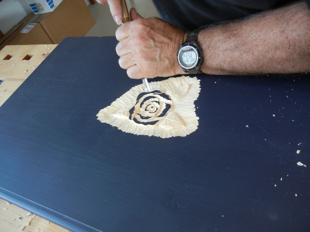 Carving a camellia flower into a painted lid.